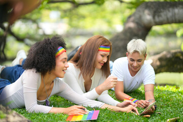 Fototapeta premium Diverse friends in park wearing rainbow headbands, celebrating pride month together