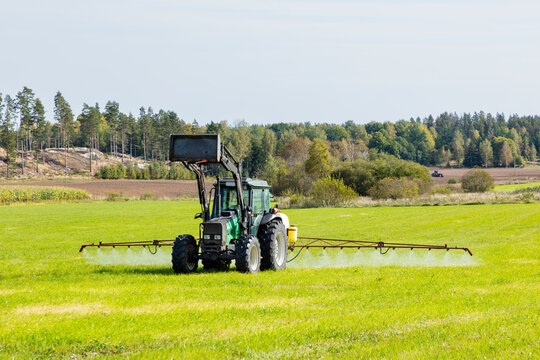 Crop sprayer tractor on agricultural field in rural area at sunny day