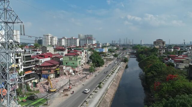 Urban aerial video frame documenting demolition and road widening project beside canal corridor along Tam Trinh Road in Hanoi.