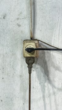 Dirty Electrical Power Outlet and Plugs on a Rough Wall