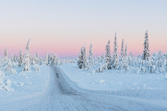 Empty road covered with snow against beautiful sky