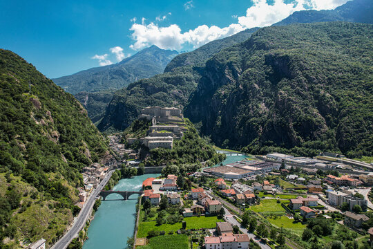 Aerial view of the historic Fort Bard perched on a rocky hill overlooking the Dora Baltea river and the alpine valley in Bard, Aosta Valley, Italy.