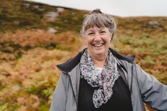 Portrait of happy mature woman standing on hill