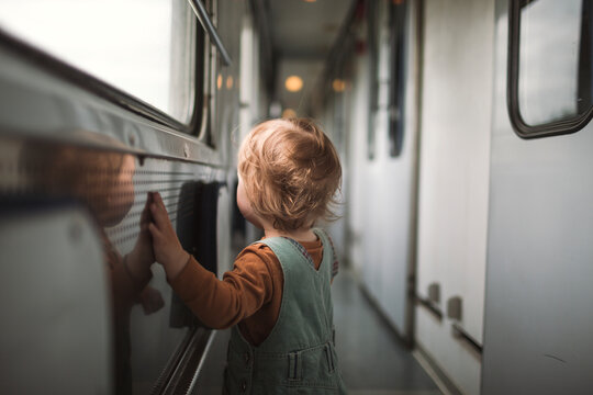 Rear view of boy walking in train aisle
