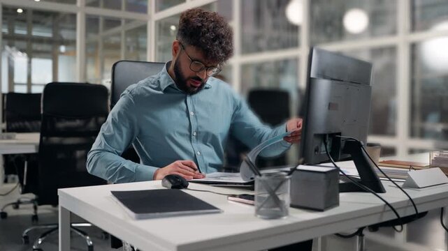 Arabian business man analyzing papers data stats diagram writing notes focused working employer write analyze finance at office ethnic businessman work specialist review documents busy with paperwork