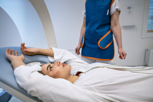 Woman lying down with arms raised while undergoing medical exam