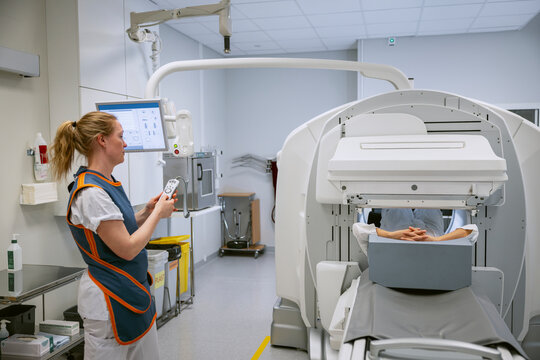 Side view of female doctor controlling MRI scanner through remote