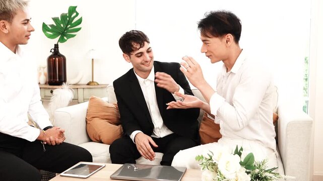 Pride and LGBTQ concept: LGBT couple, a gay man kissing a man, both romantically exchanging rings on a bed at home.

   

