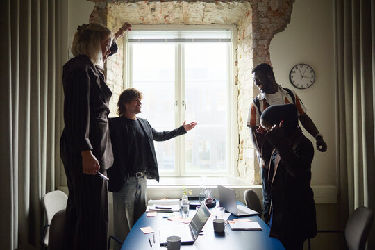 Group of happy entrepreneurs celebrating business win in meeting room