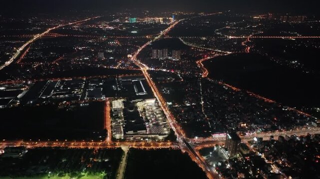 Night aerial video frame of Co Linh Road in Long Bien District, Hanoi, featuring illuminated streets, dense urban neighborhoods, and flowing traffic.