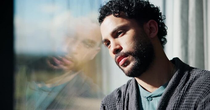 Sad, man and thinking with window for trauma, mental health or anxiety on glass in home. Thoughtful, doubt or male person with depression, reflection or regret for outdoor fear or crisis in house