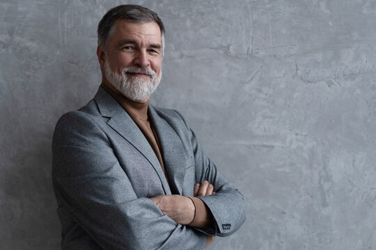 Entrepreneur in jacket smiling, Happy mid adult, mature age man standing, smiling, isolated on grey background