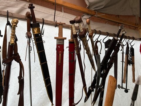 sharp weapons such as swords, machetes, karambits hanging on raffia ropes in traditional weapons 