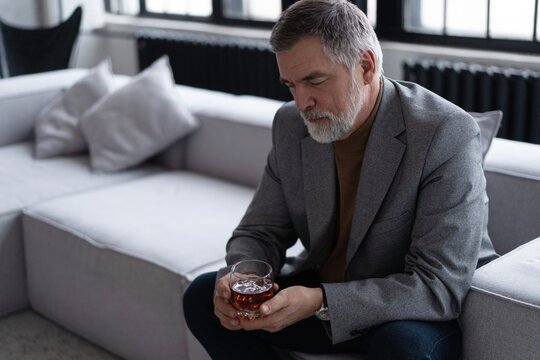 Confident mature businessman chilling relaxing drinking enjoying whiskey after work.
