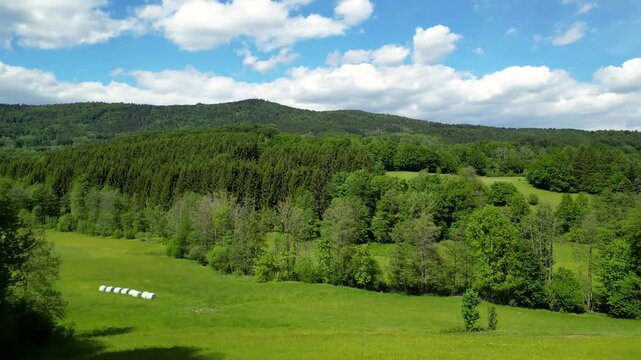 Drone footage showing forest, meadows and rolling hills under sunshine in a peaceful rural landscape of Lower Bavaria.