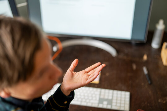 High angle view of person gesturing while sitting at desk in home office