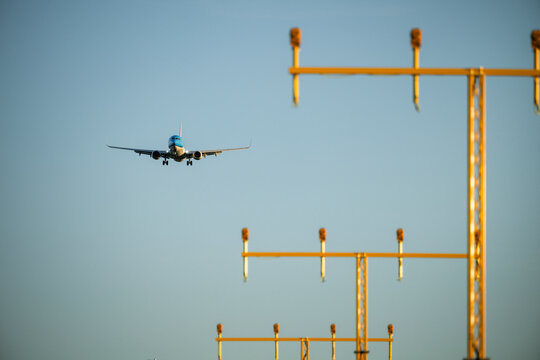 View of passenger airplane descending towards airport for landing