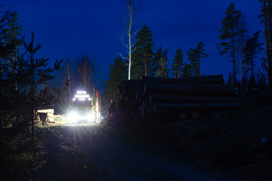 Illuminated truck at lumberyard during night