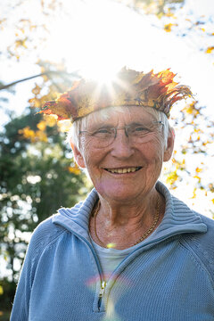 Portrait of smiling elderly woman wearing crown at sunny day