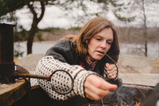 Woman burning campfire at remote outdoor location