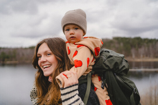 Portrait of innocent boy spending leisure time with mother carrying him on back