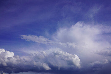Obraz premium Vivid deep blue sky gradient backdrop featuring dramatic white and purple clouds