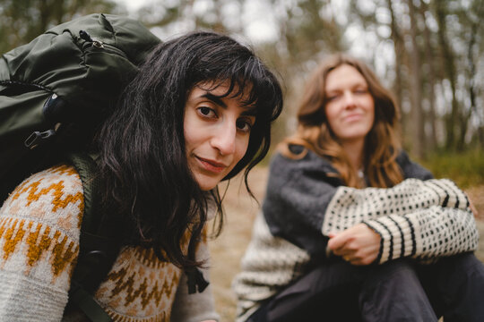 Portrait of female backpacker with bangs spending leisure time hiking in forest