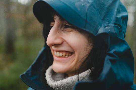 Close-up headshot of woman with toothy smile wearing raincoat