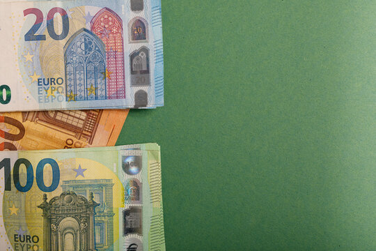 Stack of Euro banknotes viewed from above on a textured green background
