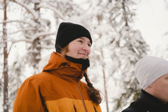 Low angle view of smiling girl with braided hair in winter forest