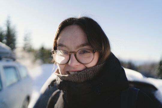 Portrait of smiling woman wearing eyeglasses along with warm clothes