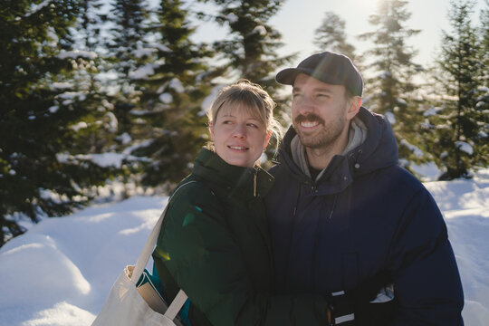 Happy couple spending leisure time in winter forest