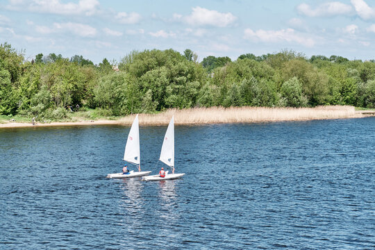 Two small sailing dinghies training on river