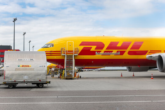 Schkeuditz, Germany - 9 May, 2026 - DHL cargo aircraft fleet parked Leipzig airport terminal  apron. Aviation air logistics scene with commercial airfreight transportation under cloudy sky
