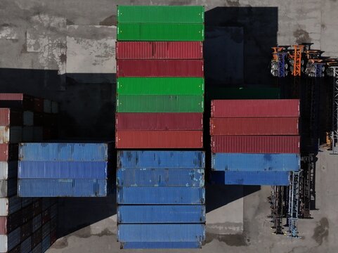 Aerial view of colorful shipping containers stacked in an industrial port terminal under bright sunlight Cincinnati, OH, United States.