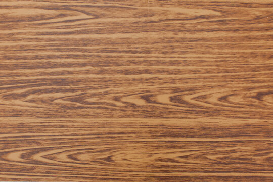 Natural brown wood grain texture background. Flat lay backdrop of smooth wooden panel surface, oak or walnut laminate pattern for furniture cladding, interior design