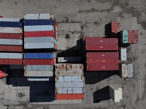 Aerial view of stacked shipping containers in a logistics terminal with long shadows on the concrete ground Cincinnati, OH, United States.