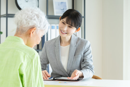 シニアの女性に説明するビジネスウーマン
