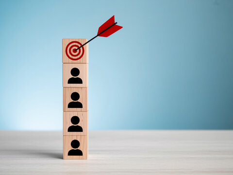Business target strategy with arrow hitting block tower of people icons, corporate goal concept