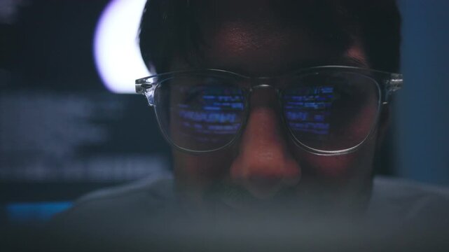Intense Focus of Software Engineer Reflecting Blue Code in Lens