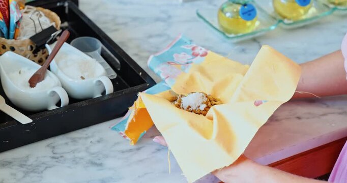 Person crafting aromatic herbal sachet using yellow cloth, hotel entertainment workshop, wellness lifestyle and hospitality marketing