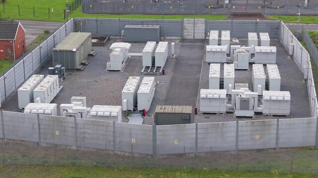 BESS Battery Energy Storage System installation made of lithium-ion. Modern green energy infrastructure, smart grid technology, energy transition, sustainable power solutions. UK. Aerial Drone Clip.