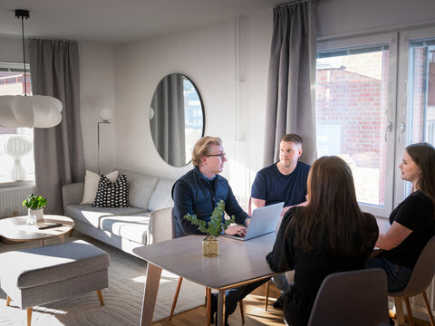 Male architect explaining home improvement plan to family members while sitting at table