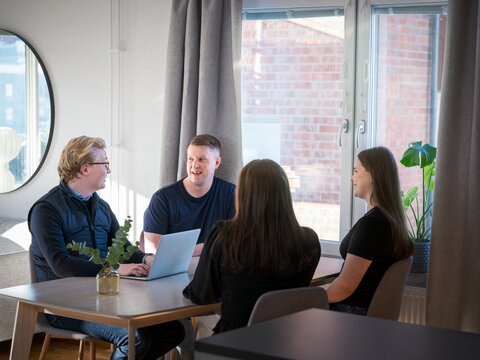 Male agent explaining home improvement plan to family members while sitting at table
