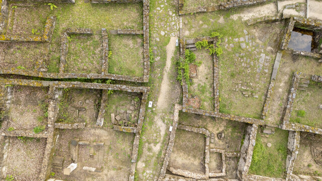 Aerial view of the ancient stone ruins of Castro de Armea featuring excavated foundations and green grass in Allariz, Province of Ourense, Spain.