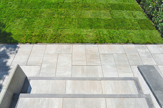 Gardening. Making a lawn from a roll. Green grass texture - well-groomed turf in the garden. View of the garden from above.