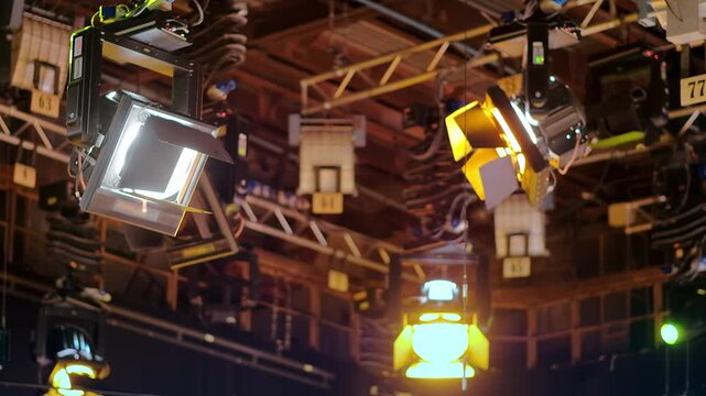 Professional studio lighting rig suspended from overhead metal trusses in television broadcast production facility.