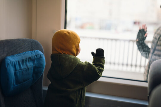 Toddler baby looking through window while traveling in train