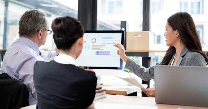 Business Team Analyzing Financial Charts on Computer Screen