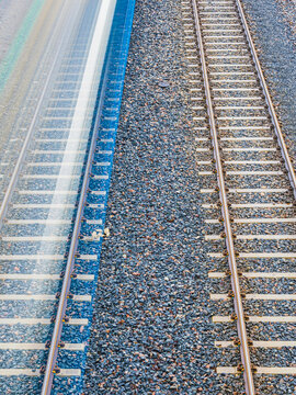 High angle view of two train tracks side by side on gravel surface